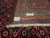 Reverse of this 10x13 wool rug showing tight even knotting, handmade tag and cotton fringe