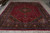 Large 10x13 traditional Persian rug displayed full length showing floral field and blue guard border