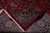 Back of the rug folded over the front, revealing tight hand-knotted weave and ivory fringe