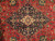 Close-up of the aubergine lobed medallion with ivory center rosette, teal leaves and coral floral accents