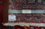 Back of the 10x13 hand-knotted wool rug beside a ruler, showing knotting and cotton warps