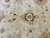 Detail of wool pile showing small brown scalloped rosette, camel palmettes and delicate tan tendrils