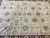 Transitional all over floral field framed by dark brown borders in a hand-knotted Peshawar rug