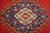 Close-up of the ivory and navy medallion showing hand-knotted wool pile and palmette detail