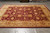 9' x 11'6" hand-knotted wool rug displayed on grey tile floor under showroom lighting