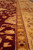 Macro of the gold minor border separating the burgundy field from the main floral border