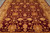 Close overhead of the all over floral field, palmettes and vine scrolls on wine red ground