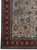 10 x 14 Tabriz rug corner showing red border, teal guard stripes and ivory rosettes