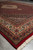 7x10 hand-knotted wool and silk rug photographed at an angle with plush red pile