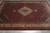 Angled overhead view of wool and silk rug with scalloped ivory medallion and side pendants