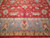 Border detail showing gold and brown palmettes with red accents above a small floral guard stripe