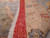 Close-up of the knotted weave, red end panel and natural ivory fringe along the rug edge