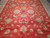 All-over floral pattern of blue palmettes and cream leaves across the antique coral red ground