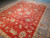 Angled full-length shot of the 9'1" x 12' Chobi Peshawar rug on polished concrete flooring