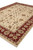 Corner to corner view of the hand-knotted wool rug with ivory fringe and red border
