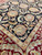 Detail of ivory guard border meeting black field, showing dense hand-knotted wool pile texture