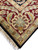 Corner of the 8 x 10 India rug showing burgundy palmette, ivory fringe and selvedge