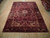 Semi-antique Heriz rug laid on light hardwood floor showing full medallion and border layout