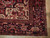 Corner detail of graphite black palmette border beside ivory spandrel with camel and blue accents