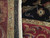 Folded edge detail showing ivory fringe, black end finish and reverse of the burgundy border