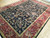 9 x 12 Indian Jaipur rug angled on wood floor, all-over vine design and wine red border