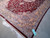 Gold spandrel corner detail with navy vines, cream blossoms and burgundy selvage edge