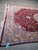 Angled corner of the 7x10 burgundy rug showing bamboo silk sheen and long fringe