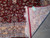 Folded corner revealing fine machine woven back, white fringe and gold paisley border detail