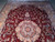 End view of burgundy Tabriz design rug with medallion, pendants and gold corner spandrels