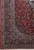 Corner detail showing multi-band border, rose and light blue palmettes and dense wool pile