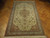 Angled floor view of the hand-knotted Tabriz rug, terracotta corner spandrels and ivory scrolling border