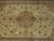 Close-up of the tan brown central medallion with fine floral tracery on ivory wool pile