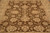 Overhead detail of brown field covered in cream palmettes, curling leaves and slender connecting vines