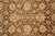 Close-up of hand-knotted wool pile showing beige rosettes, soft grey accents and small red highlights