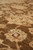 Angled macro of dense wool pile revealing the olive brown ground and cream floral drawing