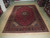 10x14 Persian Kashan rug displayed flat on a light wood floor in the rug warehouse