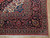 Corner detail showing navy border, rose palmettes, layered guard stripes and clean ivory cotton fringe