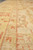 Angled view of the gold main border with rust vine motifs and inner guard bands