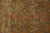 Detail of all-over floral pattern showing coral, gold and brown vines across soft green wool pile