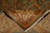 Back of the rug folded over the front, showing tight knotting, green selvage and ivory fringe