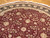 Close view of wine red field with ivory palmettes, scrolling vines and dark border detail