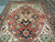 10 by 14 Serapi area rug on showroom floor, rust field with ivory corner spandrels