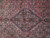 Close-up of navy inner medallion surrounded by salmon red Herati lattice and tiny rosettes