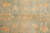 Gold pomegranate and lattice motifs scattered across the pale teal green wool ground