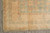 9 x 12 hand-knotted Pakistani rug corner with gold Greek key border on grey tile