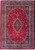 Overhead full view of deep red Persian Mashad rug with navy floral medallion and ivory border