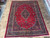 8'8" x 11'6" Mashad rug photographed on travertine tile showroom floor from directly above