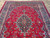 Red field 9x12 Persian rug with navy medallion and curling acanthus leaves in blue