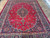 Full length angle of 8'8" x 11'6" Mashad rug showing symmetrical floral field and border