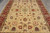 Close overhead of beige floral field with teal palmettes, salmon blossoms and burgundy accents throughout